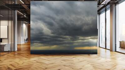 Panorama with a view of the rapidly approaching thunderstorm, the sun's rays shining through the clouds. Wall mural