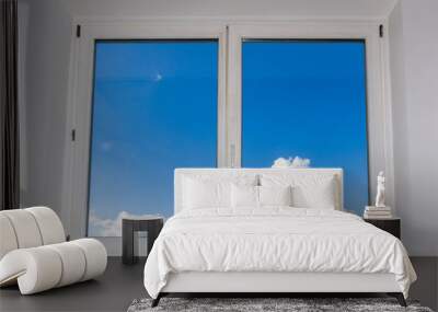 View of closed white window overlooking blue sky with clouds, view from home Wall mural