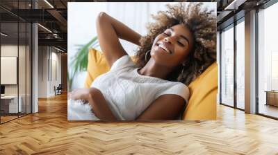 Happy black woman relaxing lying on the sofa at home , Portrait of comfortable girl laughing on the couch , Healthy lifestyle concept with young female smiling at camera. Wall mural