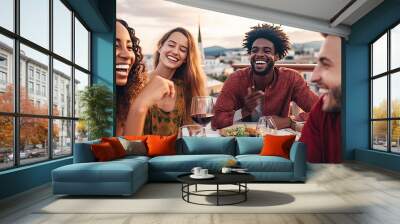 Multiethnic friends having fun at rooftop bbq dinner party , Group of young people diner together sitting at restaurant dining table , Cheerful multiracial teens eating food and drinking wine outside Wall mural