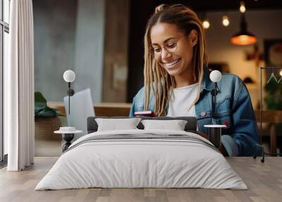 Woman smiling and using mobile for online payment in a coffee shop Wall mural