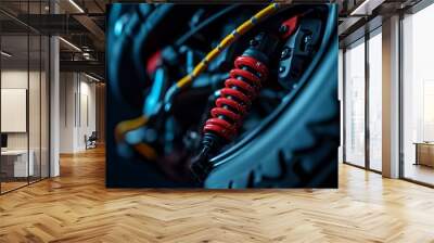 Close-up of a red shock absorber on a motorcycle with a black tire and a yellow cable. Wall mural