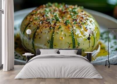 Close-up of a roasted round vegetable with a brown sauce and fresh herbs on a white plate. Wall mural