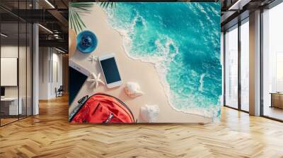 A picture showing the idea of a summer vacation: a travel bag, beach stuff, and a smartphone on a beautiful sandy beach with the ocean in the background. Wall mural