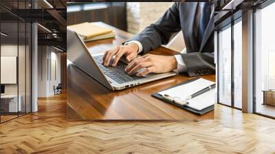 A stenographer's hands rapidly typing on a laptop keyboard during a formal deposition, with legal documents and pens scattered across a wooden conference table. Wall mural