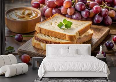 Freshly made sandwich featuring creamy peanut butter spread evenly between two slices of soft white bread, placed on a rustic wooden table with a side of grapes. Wall mural