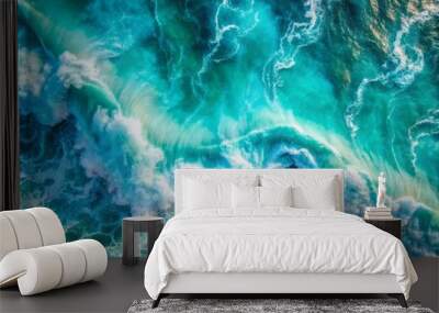 Vibrant turquoise ocean water with dynamic splashes and foamy waves creates a stunning abstract natural background and texture in this breathtaking overhead aerial view. Wall mural