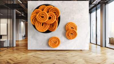 Crunchy fried homemade Chakli in a bowl with sesame seeds. Chakli is a savory snack from India made out of rice, mixed yellow and green lentils along with spices. Mostly eaten during Diwali festival Wall mural