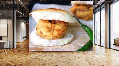 Vada pav or wada pao is a vegetarian fast food dish native to the state of Maharashtra. Famous Mumbai street food served with green chutney and fried green chili. Copy space Wall mural