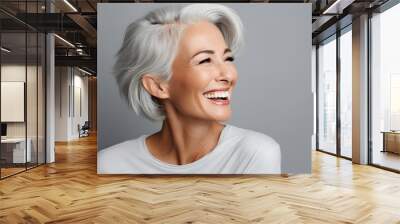 A cheerful elderly woman with white hair laughing heartily, exuding happiness and positivity. Beautiful gorgeous 50s mid age beautiful elderly senior model woman with grey hair laughing and smiling. Wall mural