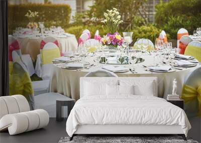 Wedding reception dinner table setting with flower decoration and white cover chairs yellow sash Wall mural