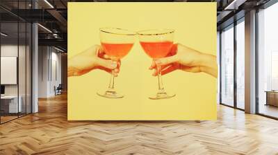 Two People Clinking Glasses with Aperitifs on Yellow Background Wall mural