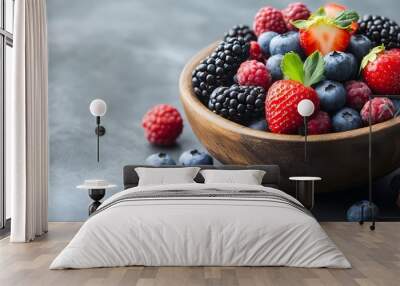 A bowl of mixed berries including blueberries and raspberries. The bowl is wooden and the berries are fresh and colorful Wall mural