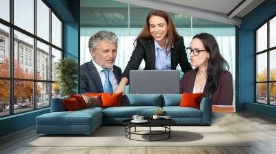 Cheerful confident manager sharing ideas with colleagues, showing presentation on computer. Business team discussing project, looking at laptop display. Communication concept Wall mural