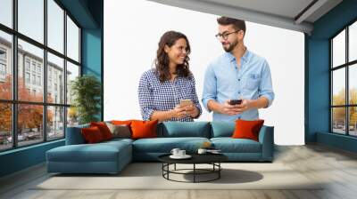 Cheerful couple using cellphones, texting messages. Young woman in casual and man in glasses in glasses posing isolated over white background. Wireless technology concept Wall mural