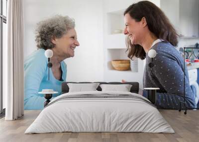 Cheerful senior mother and adult daughter sharing good news Wall mural