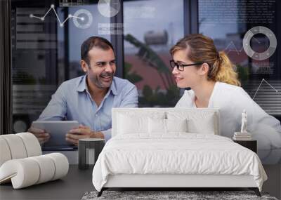 Colleagues talking in office and virtual statistic graphics. Portrait of male and female communicating. Young Caucasian businesswoman and mid adult bearded man with digital tablet. Corporate concept Wall mural