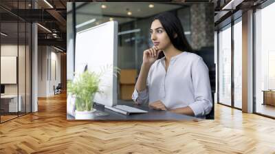 Confident young businesswoman working in office Wall mural