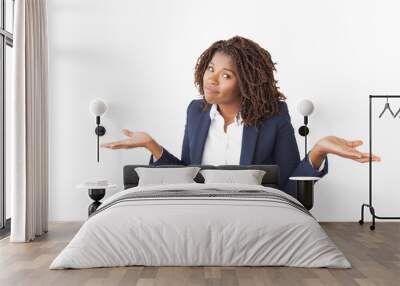 Confused office worker making clueless gesture. Young African American business woman standing isolated over white, looking at camera, shrugging. Do not know concept Wall mural