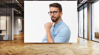 Content satisfied male customer touching chin and looking at camera. Handsome young man in casual shirt and glasses standing isolated over white background. Male portrait concept Wall mural