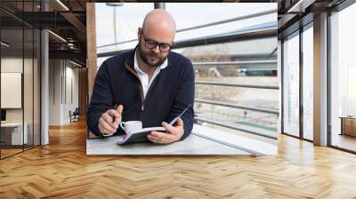 Focused businessman checking daily planner Wall mural