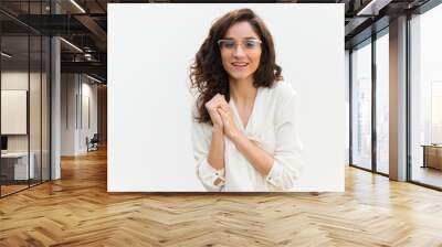 Front view of smiling young woman in eyeglasses. Cheerful curly lady looking at camera. Female beauty concept Wall mural