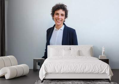 Happy androgynous businesswoman posing in studio. Middle aged woman in office suit standing over white background, keeping hands in trousers pocket and smiling at camera. Business portrait concept Wall mural