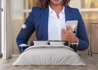 Happy cheerful professional with tablet posing outside. Young African American business woman standing at glass wall, holding digital device, looking away, smiling. Happy entrepreneur concept Wall mural