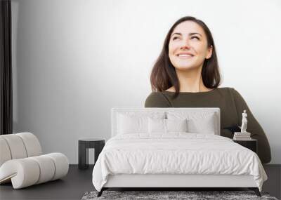 Happy confident beautiful woman with arms crossed looking up at copy space, and smiling. Young woman in casual standing isolated over white background. Promotion concept Wall mural