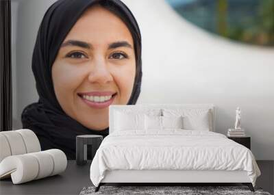 Happy confident Muslim business lady posing outside. Closeup portrait of beautiful young business woman in black hijab smiling at camera. Muslim businesswoman concept Wall mural