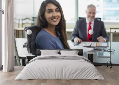 Happy female candidate after successful job interview. Young Indian woman in casual smiling at camera after talking to mid adult business man in meeting room. Meeting or employment concept Wall mural