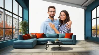 Happy satisfied family couple hugging and posing for camera. Young woman in casual and man in glasses standing isolated over white background. Relationship and affection concept Wall mural