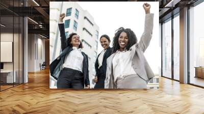 Happy successful female business team celebrating success. Business women posing outside in city. Success or teamwork concept Wall mural