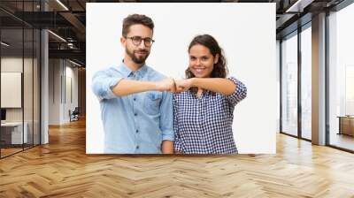 Happy united couple making fist bump gesture. Young woman in casual and man in glasses standing isolated over white background. Collaboration concept Wall mural