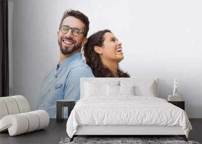 Joyful carefree couple leaning on each other, chatting and laughing at joke. Young woman in casual and man in glasses in glasses posing isolated over white background. Sweet couple concept Wall mural