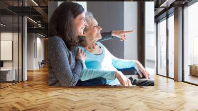 Joyful woman taking care of elderly mother Wall mural