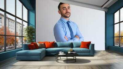 Portrait of serious confident businessman. Handsome sales agent wearing blue shirt and tie crossing arms and looking at camera. Business success concept Wall mural