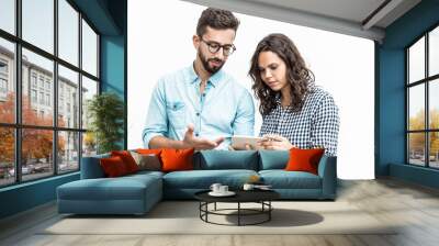 serious puzzled couple reading message on tablet screen. young woman in casual and man in glasses in Wall mural