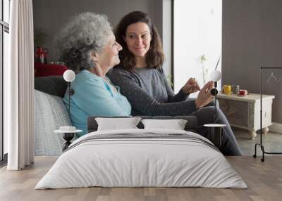 Smiling senior woman and her daughter using tablet computer Wall mural