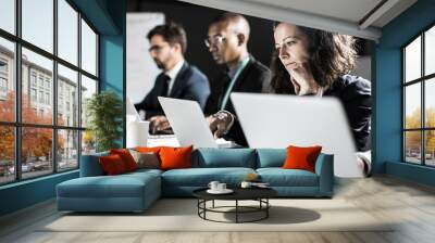 Thoughtful business team working at night in office. Tired woman leaning on hand and looking at laptop screen. Overwork, working late concept Wall mural