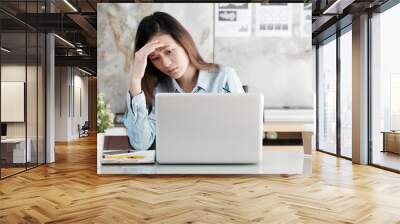 Businesswoman looking at laptop computer with stressed face at desk office, business situation, office lifestyle Wall mural