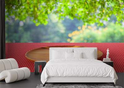 empty round wooden tray on red polka dot tablecloth over blur tr Wall mural