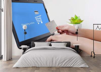 Woman hands holding credit card and typing labtop with shopping online on screen background, selective focus, shopping online concept, business and technology Wall mural