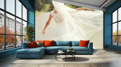 happy brunette bride spinning around with veil Wall mural