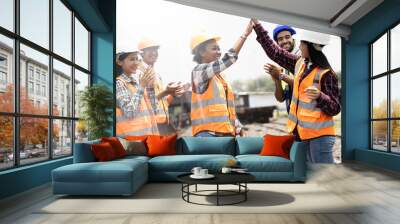 A group of young engineers are happily chatting at the machine work site at the railroad tracks. Wall mural