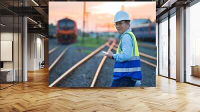 Engineering walking on the railway and sunset background. Wall mural