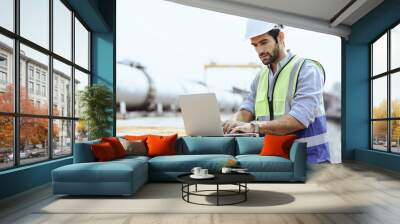 Heavy-duty industrial engineers stand in a pipeline manufacturing facility using digital tablet computers for the construction of products to transport oil, gas and fuel. Wall mural