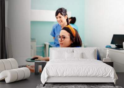 Two nurses using a computer in a x-ray room Wall mural