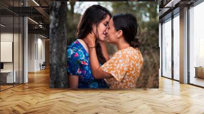 Two women kissing in the woods with dresses Wall mural