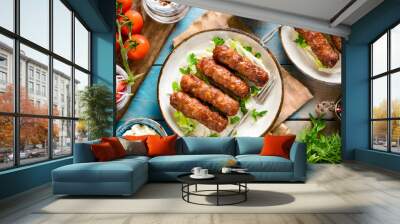 A traditional Balkan dish, Cevapi, served with fresh vegetables and flatbread Wall mural